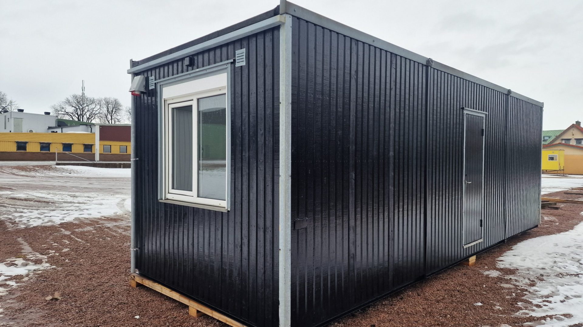 Svart kontorsbod med träfasad och öppen planlösning